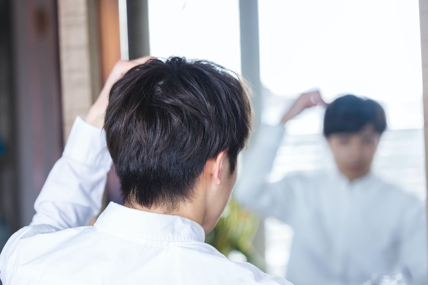 鏡を見る男性