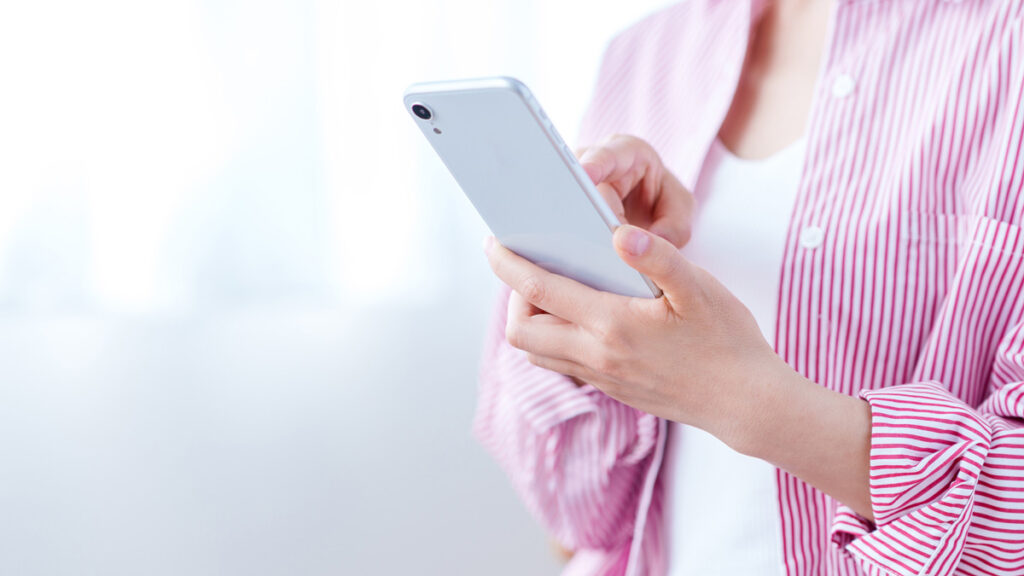 スマホで予約をしている女性